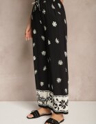 sophyline paris Pantaloni negri din vâscoză cu croială largă cu elastic în talie cu imprimeu floral Nimilassa