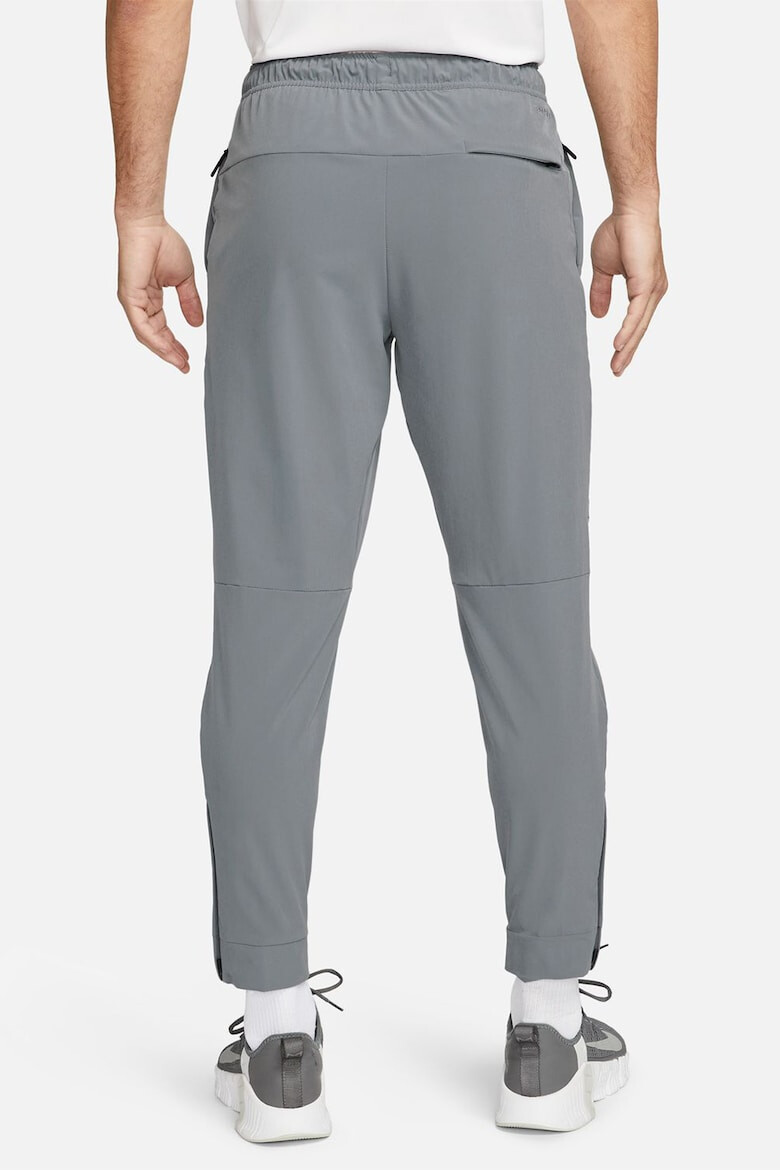 Nike Pantaloni conici cu tehnologie Dri-FIT si slituri cu fermoar Unlimited - Pled.ro